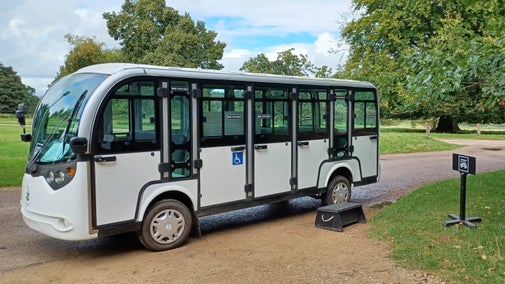 Shuttle bus against a backdrop of trees